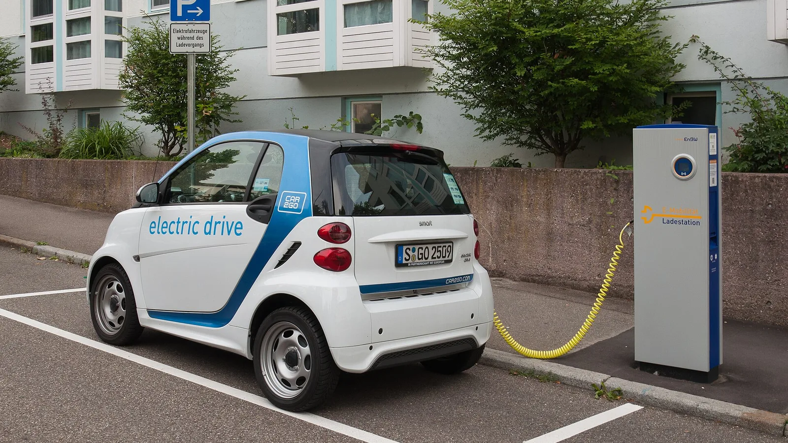 A small electric car plugged into a charging station