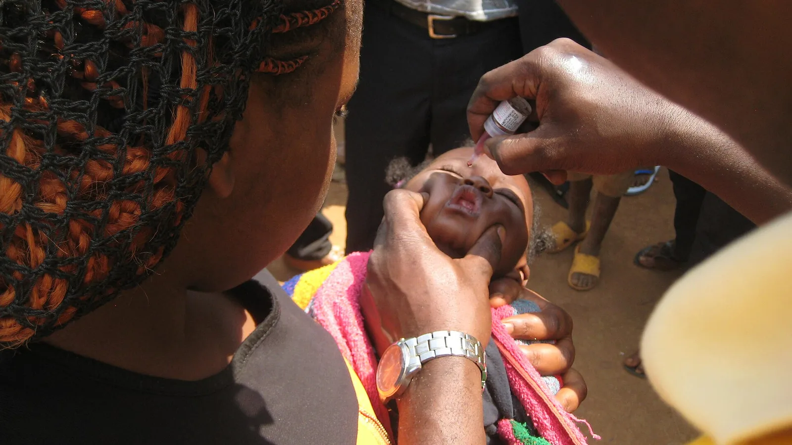 A young child receives an oral vaccine dose during an immunization campaign.